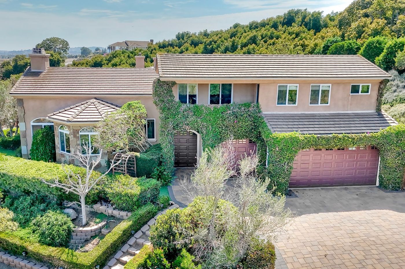Ivy-draped front elevation and paver motor court of 2484 Dos Lomas, Fallbrook