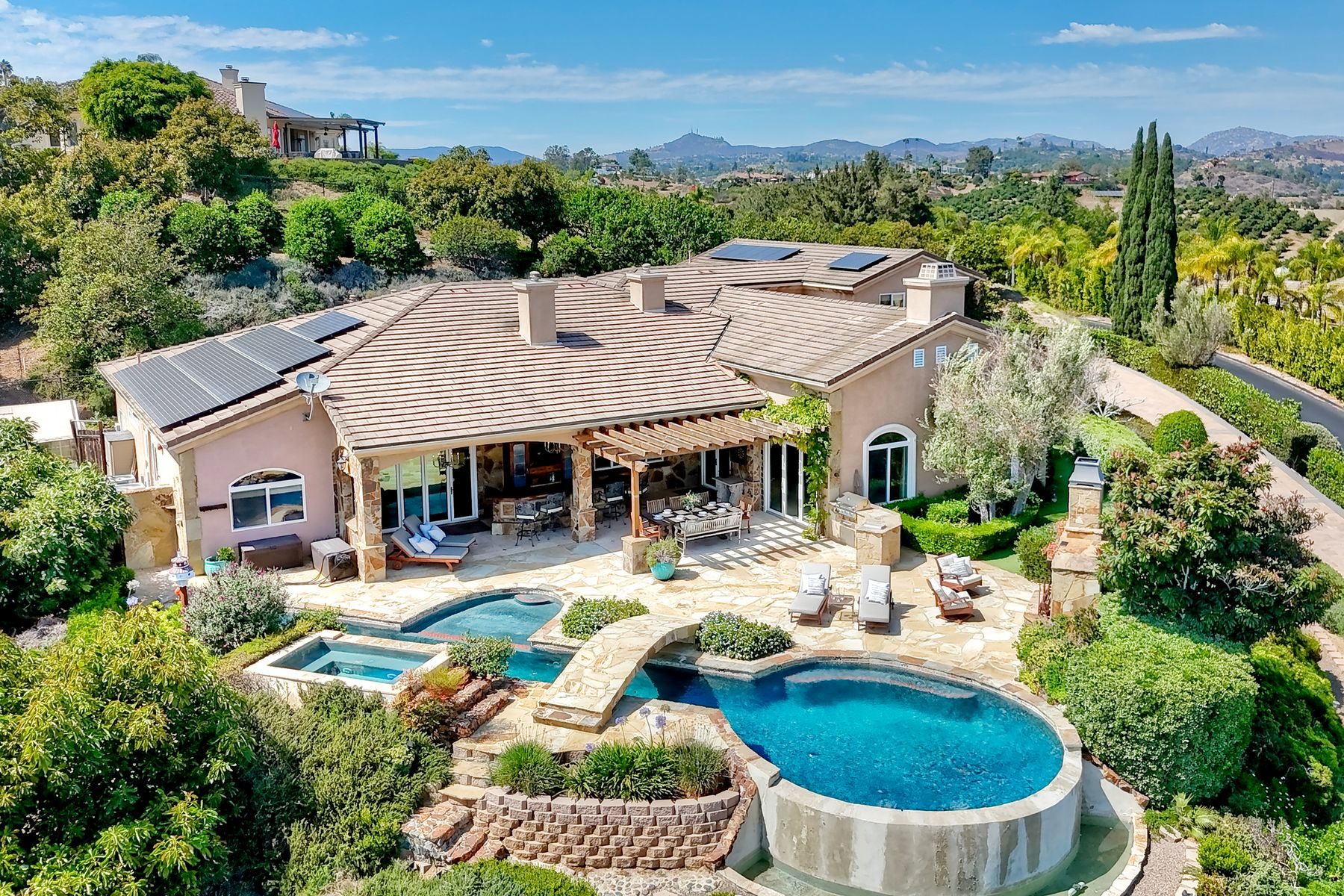 Aerial view of 2484 Dos Lomas estate, pool complex, and Champagne Crest hills