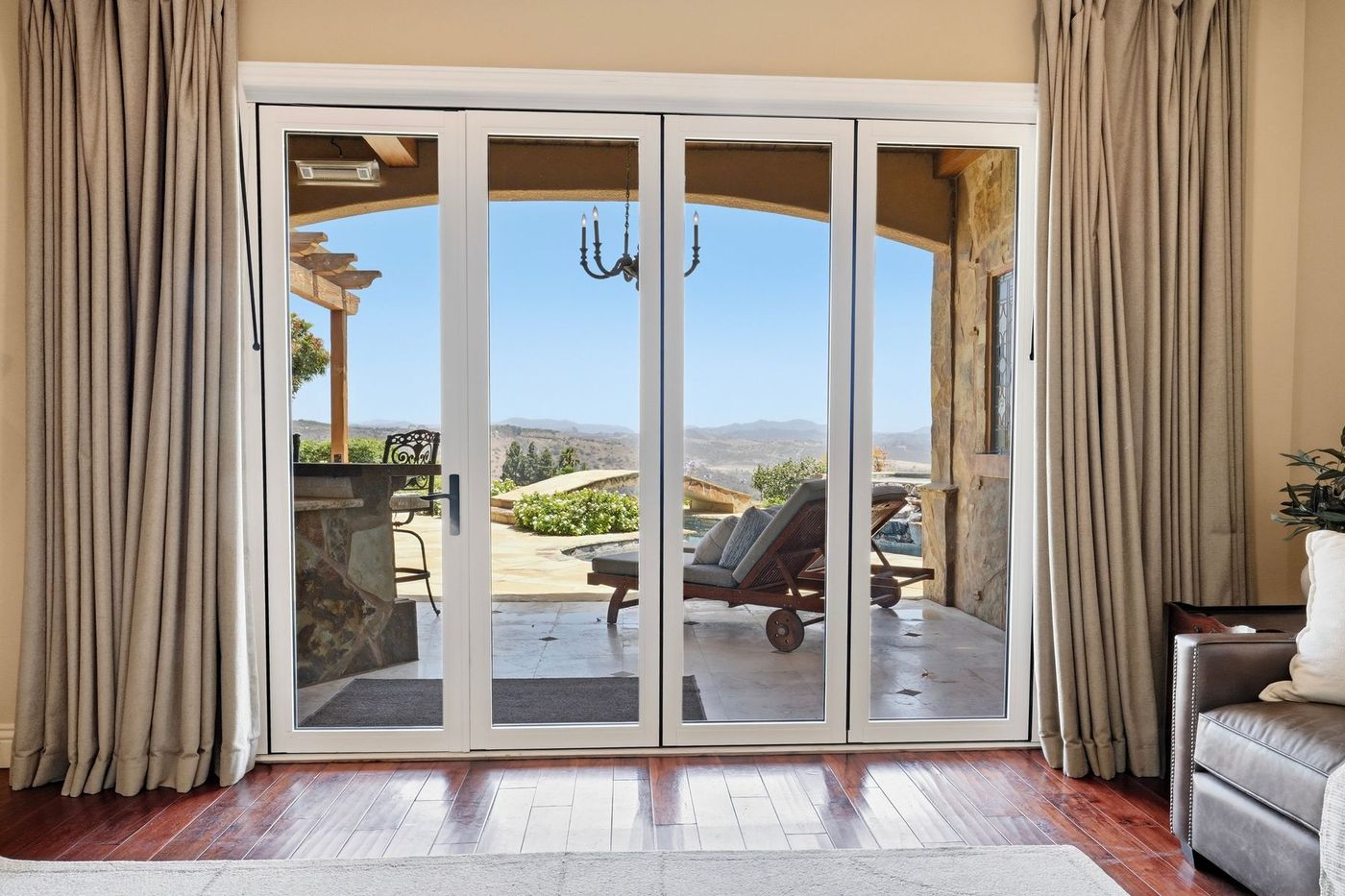 Full-wall folding glass doors opening from the primary suite to the covered patio
