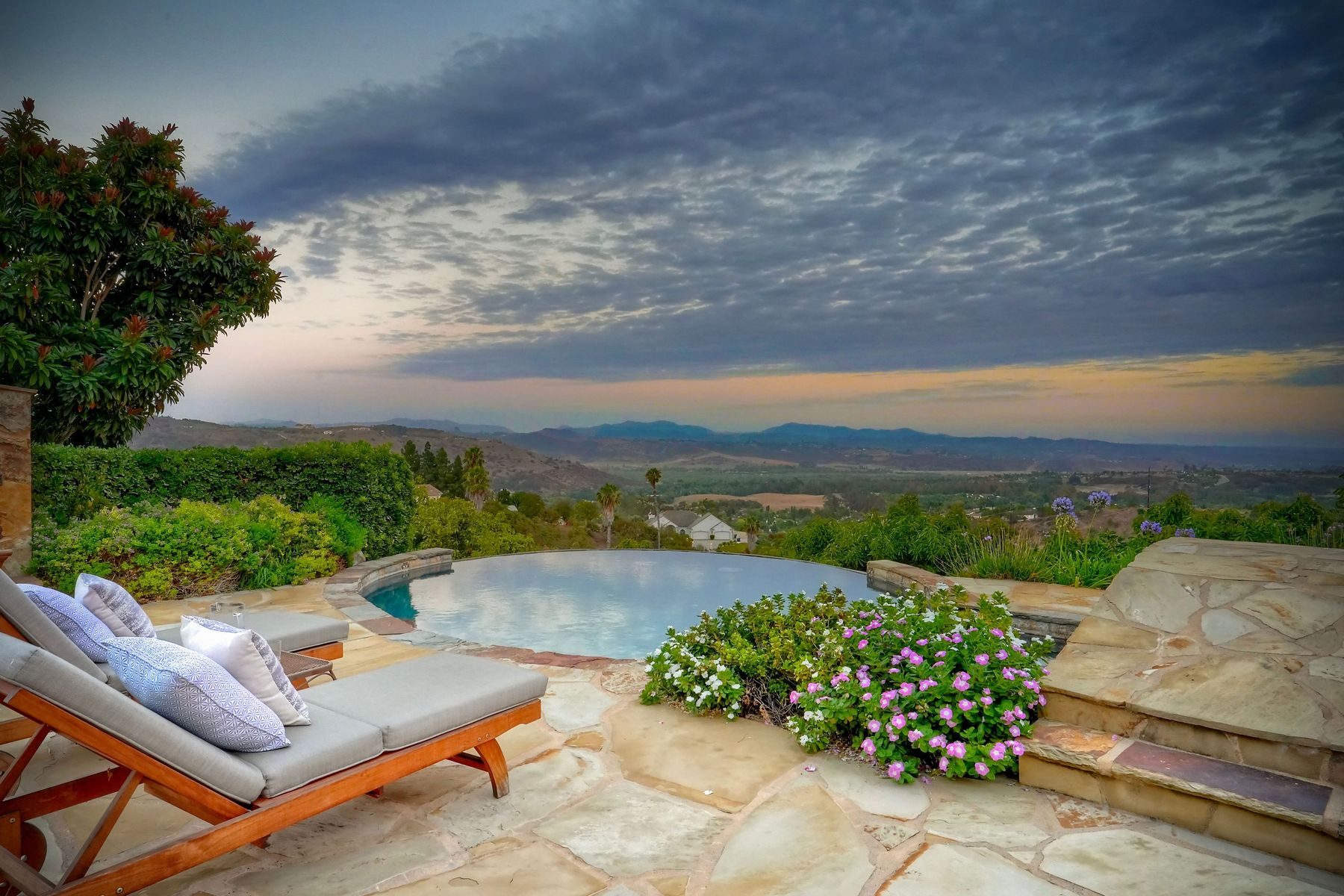 Infinity-edge pool at sunset overlooking the Gird Valley and Palomar Mountains